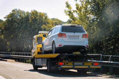 Stalled SUV being towed on a flatbed truck